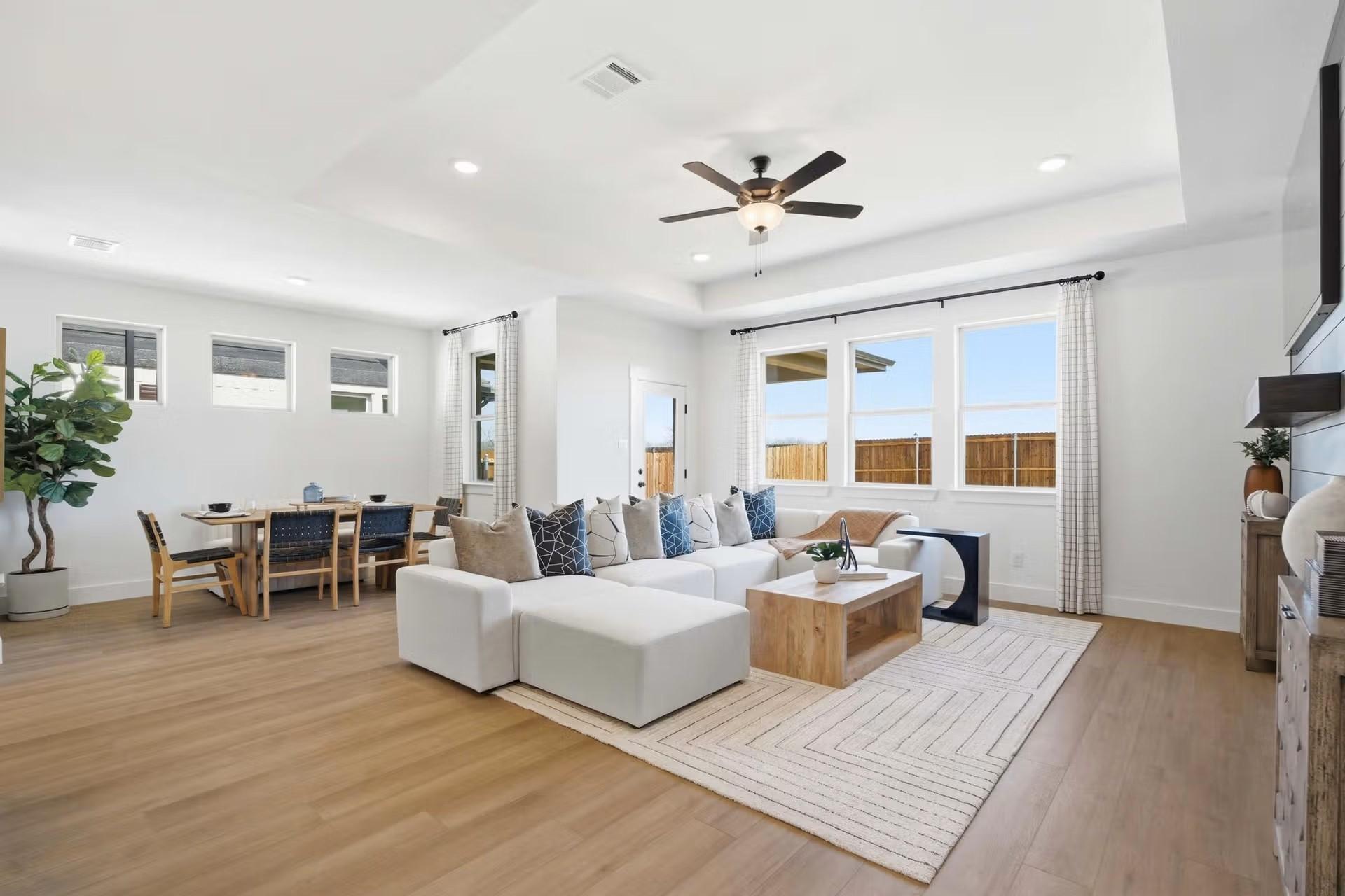 Open-concept living room with tray ceiling and dining area in The Laurel O floor plan by Davidson Homes, Royse City, Texas.
