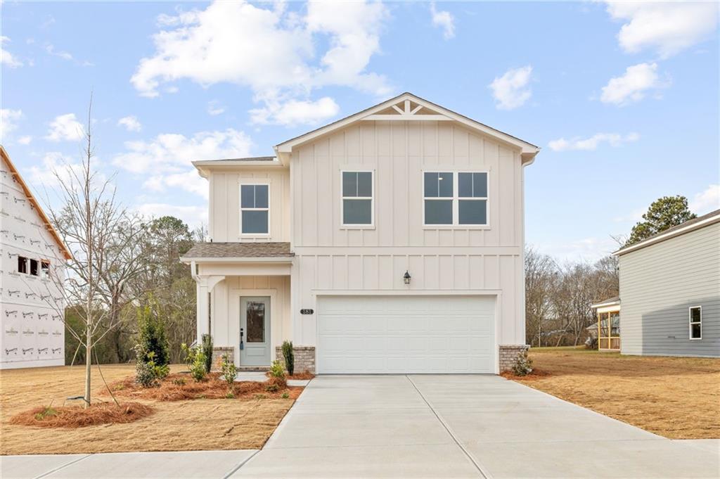 Charming two-story Rabun C home by Davidson Homes in Cedar Farms, Winder, GA: white board-and-batten siding, 2-car garage, front porch