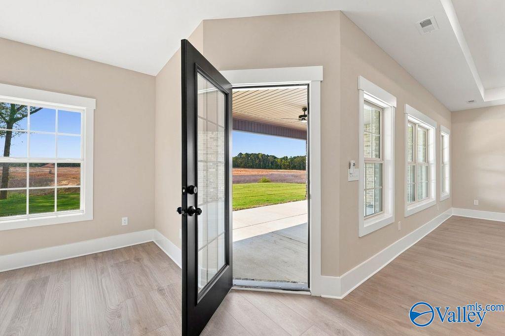 Open door leading to a covered patio and backyard view in a Rockford floor plan home at Cain Park, Hartselle, Alabama.