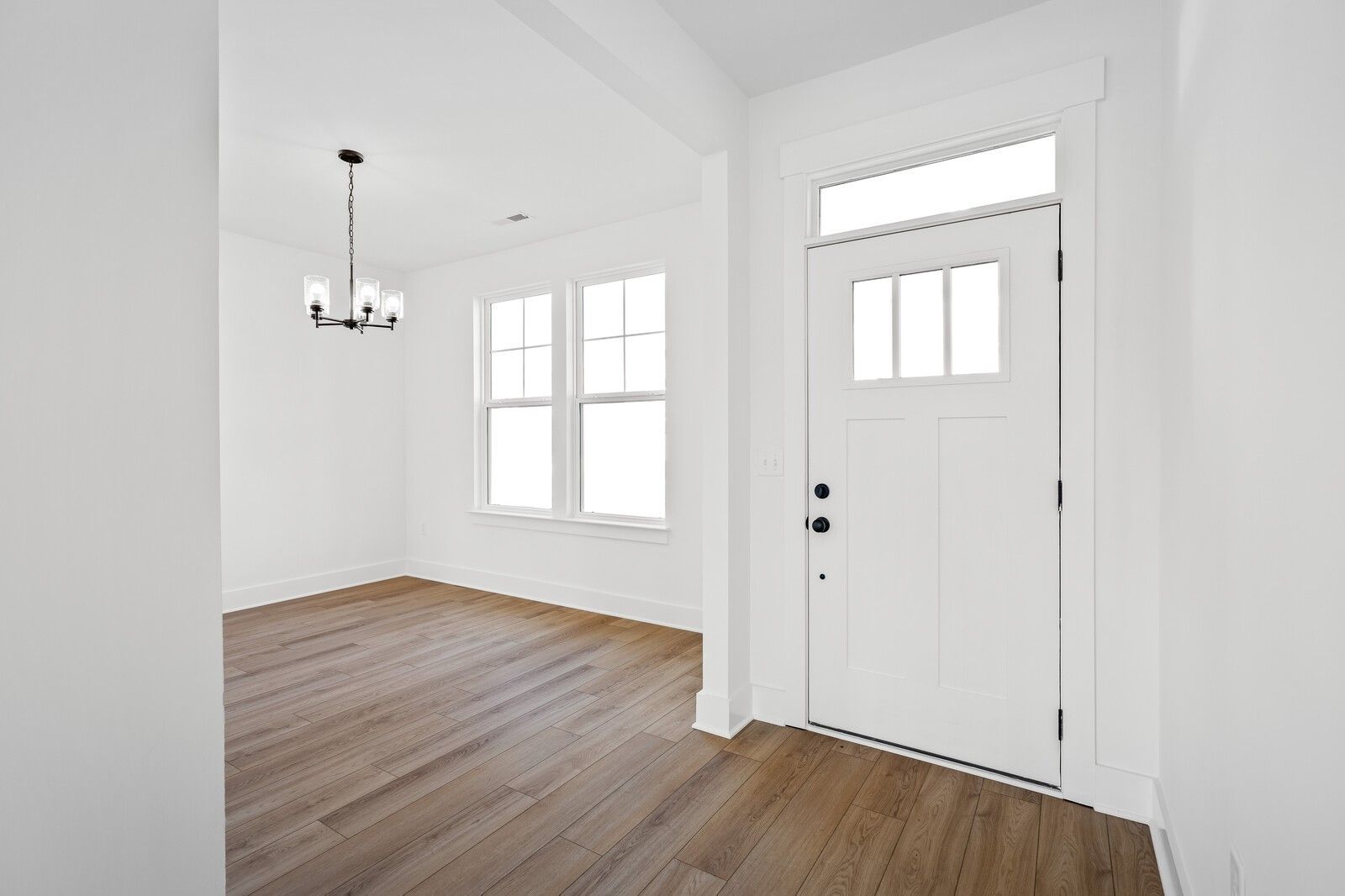 Bright entryway with hardwood floors, chandelier, and white glass-paneled door in Davidson Homes The Willow C, Gallatin, Tennessee