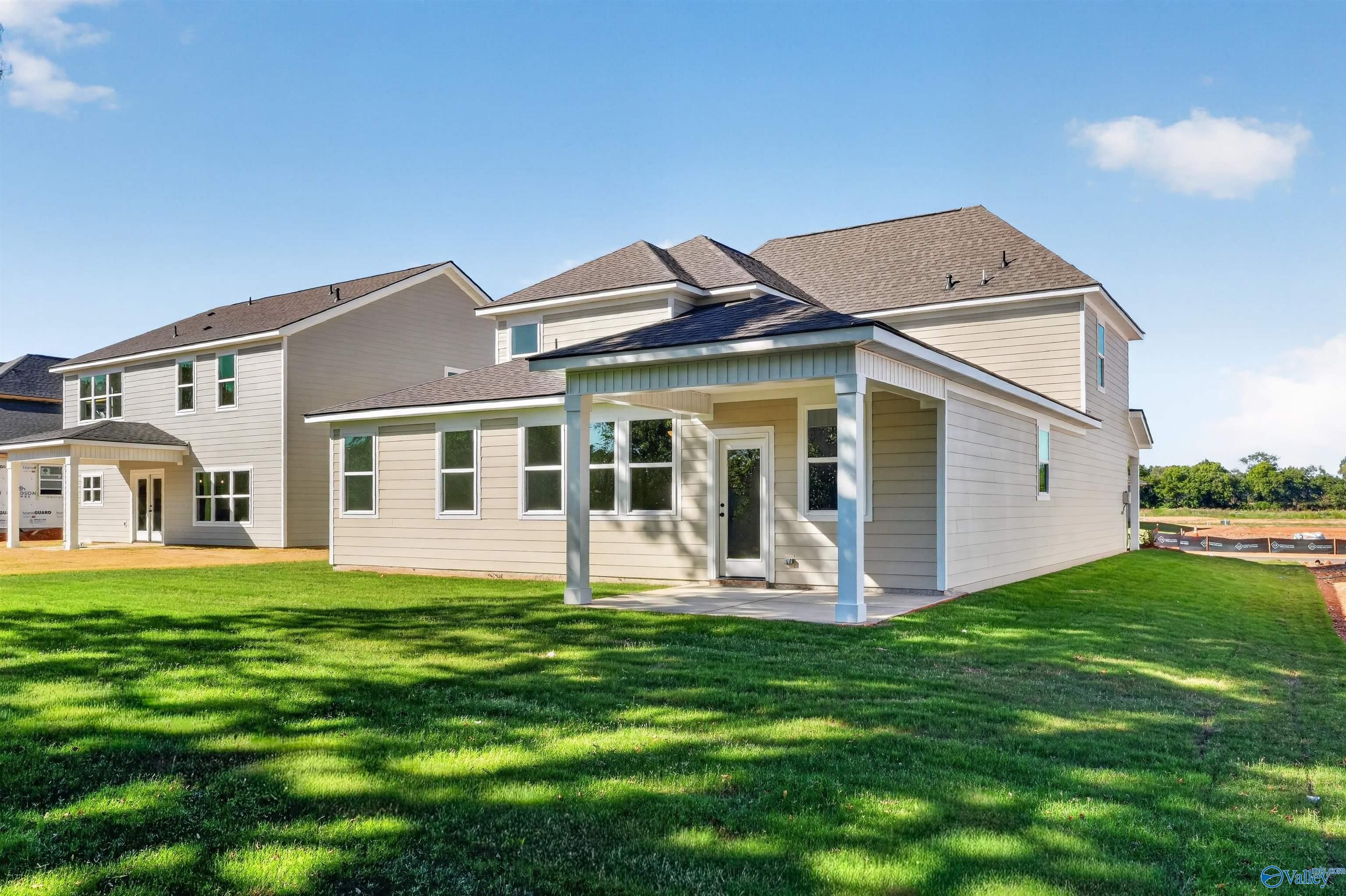 Covered back patio on 2-story Davidson Homes Ashport L plan with lush backyard in Berry Cove, New Market, Alabama