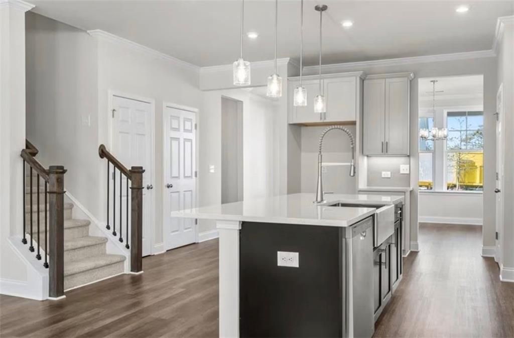 Modern kitchen with large island and pendant lighting in The Ash C floor plan at Wehunt Meadows, Hoschton, Georgia.