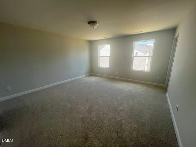 Bright secondary bedroom with large windows, neutral walls, and plush carpet in The Adalynn A, Davidson Homes, Lillington, NC