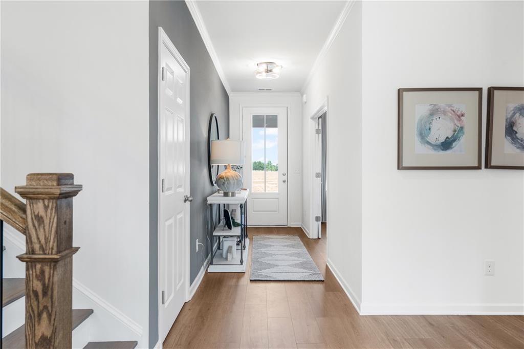 Bright foyer with hardwood floors, modern accent wall, and console table in The Hickory G floor plan, Fern Hollow, Buford.
