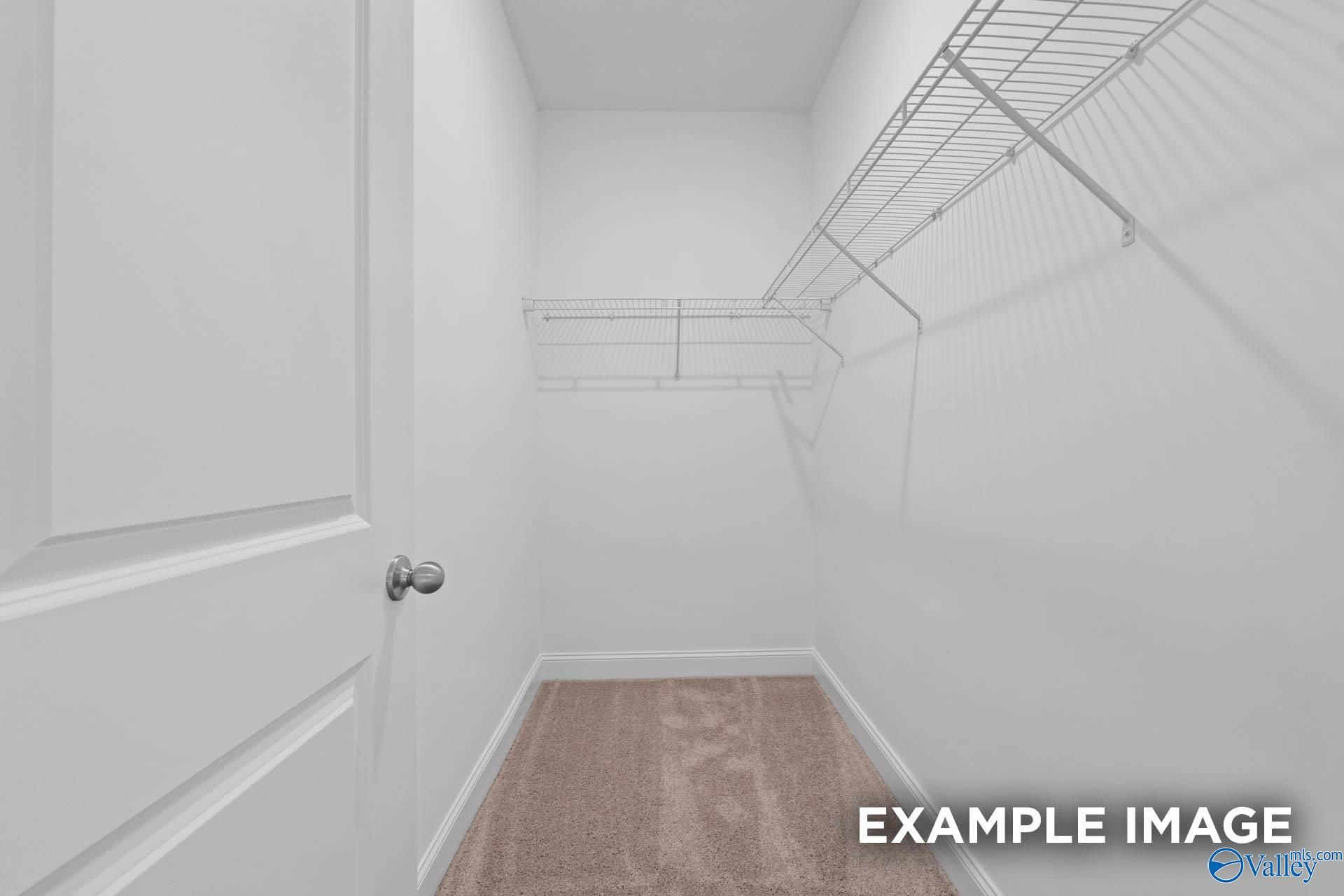 Spacious walk-in closet with white wire shelving and hardwood floors in Davidson Homes The Butler, Owens Cross Roads, Alabama