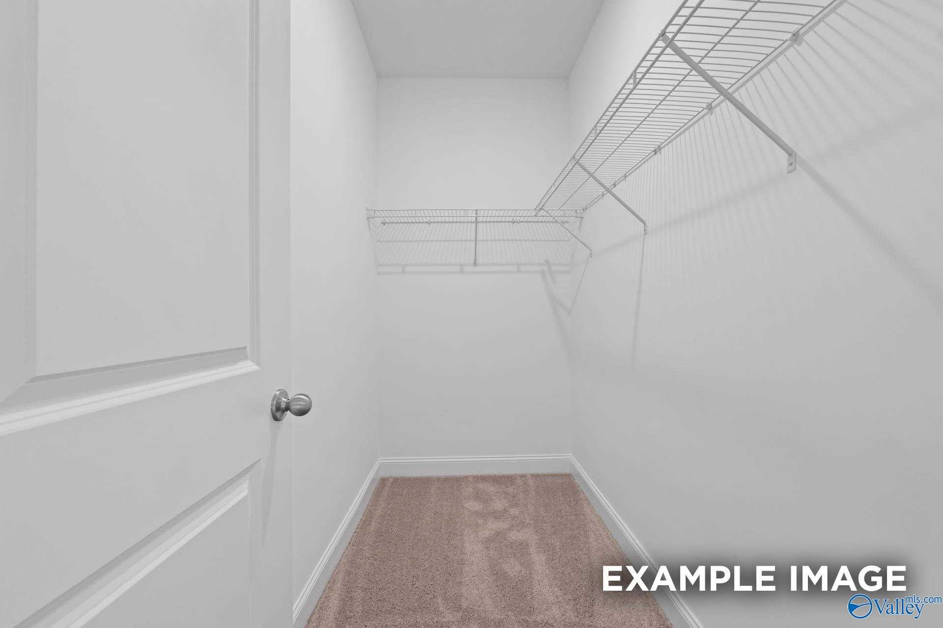 Spacious walk-in closet with wire shelving and hardwood floors in Davidson Homes The Butler, Huntsville Alabama