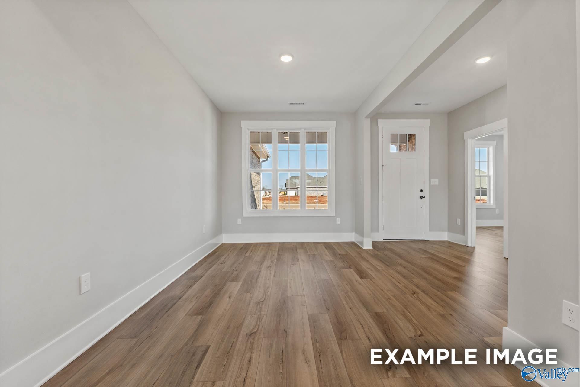 Bright, modern living area with wood-look flooring in The Finleigh floor plan by Davidson Homes in Briercreek, Meridianville.