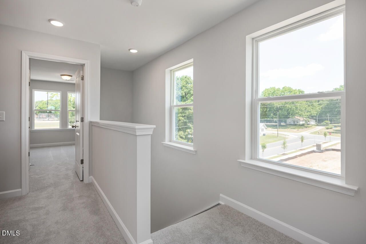 Bright second-floor landing with carpet and large windows in The Mitchell home at Camden Park, Knightdale, North Carolina.