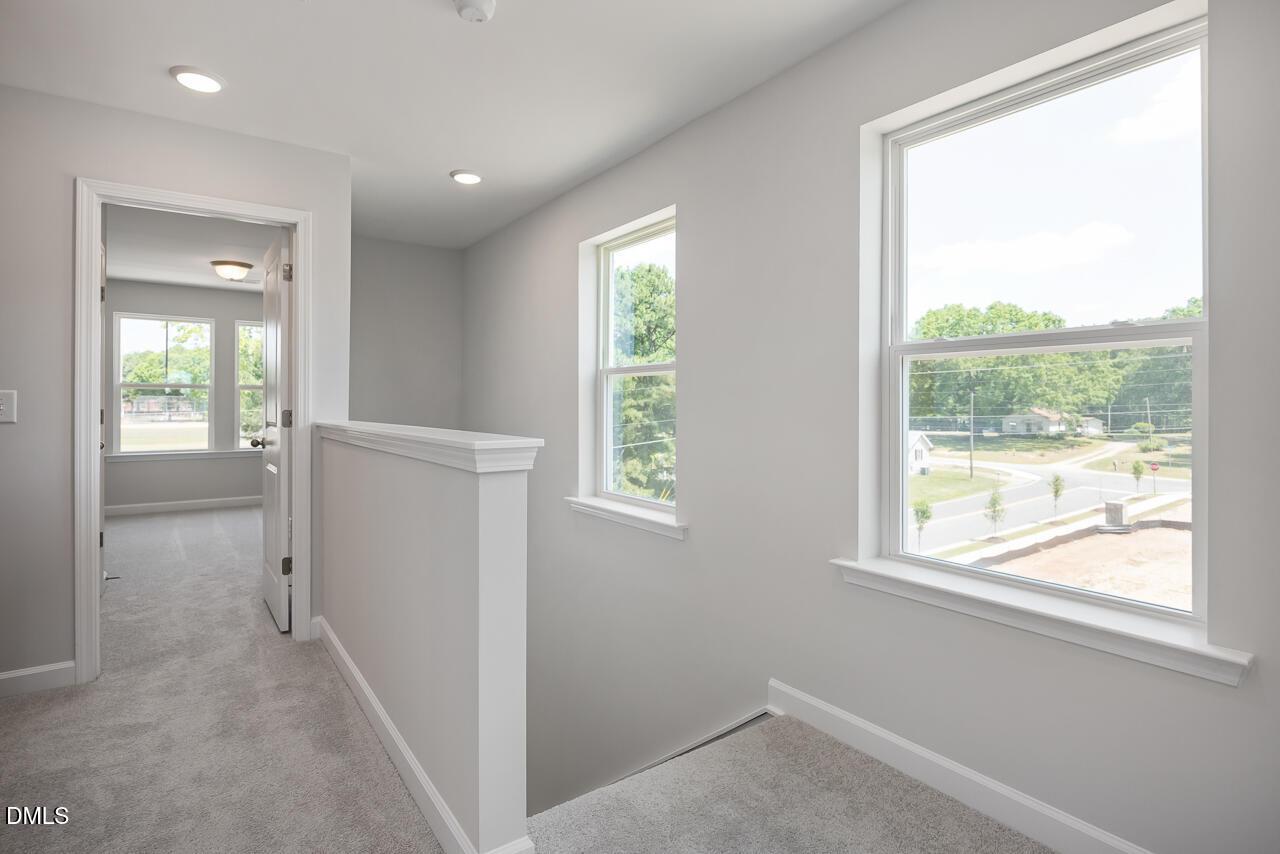 Bright second-floor landing with carpet and large windows in The Mitchell home at Camden Park, Knightdale, North Carolina.