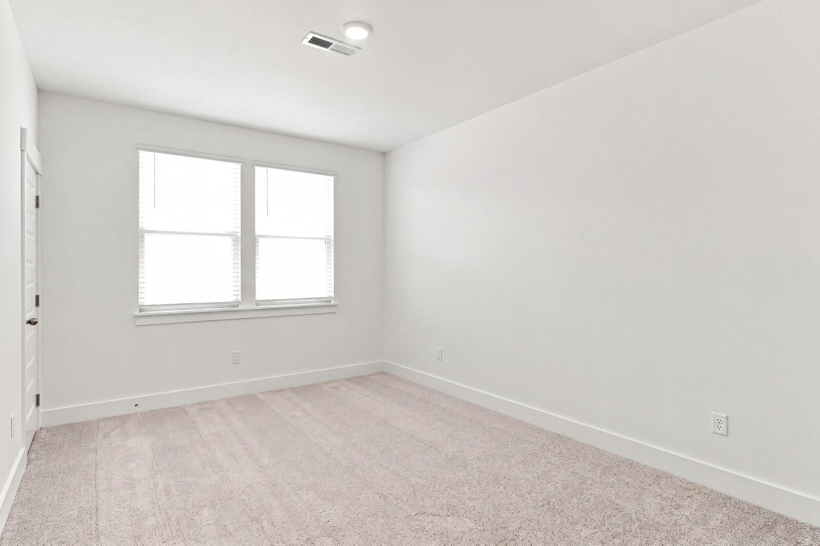 Bright carpeted bedroom with double windows in Davidson Homes The Willow C, Woods Crossing, Gallatin, Tennessee