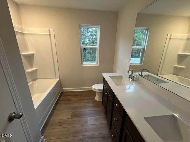 Full bathroom with tub-shower combo, white vanity countertop, and dark wood cabinets in Davidson Homes The Willow D, Lillington, NC