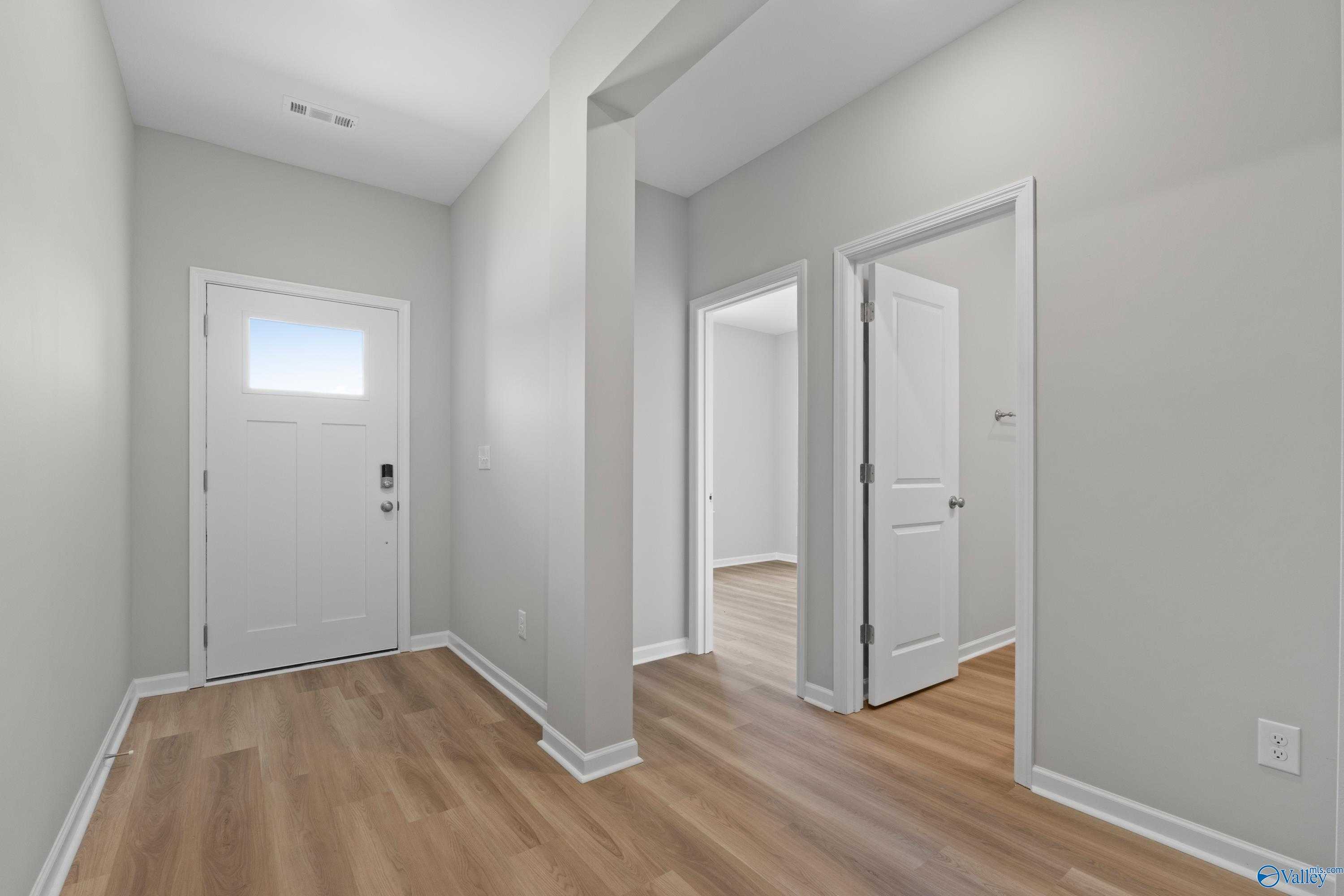 Bright entry foyer with white doors, gray walls, and light wood floors in Davidson Homes The Polaris, Fayetteville TN