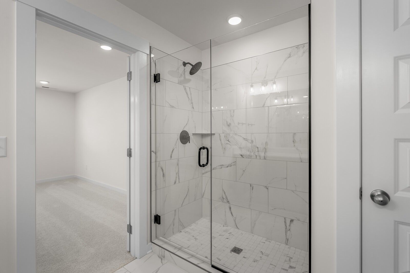 Modern walk-in shower with marble-look tile and glass door in The Willow plan by Davidson Homes, Gallatin, Tennessee.