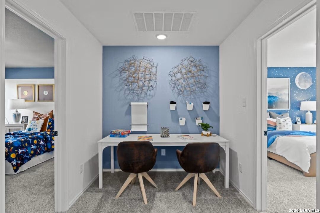 Upstairs study nook with blue accent wall, metallic art, white desk, and starry kids' bedrooms in Davidson Homes The Douglas C, Converse, Texas