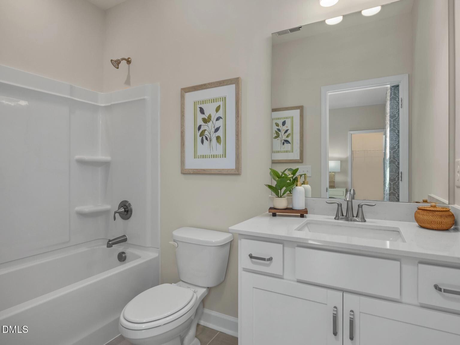 Bright bathroom featuring white bathtub, walk-in shower, vanity sink, and mirror in Davidson Homes The Hickory II D, Wake Forest