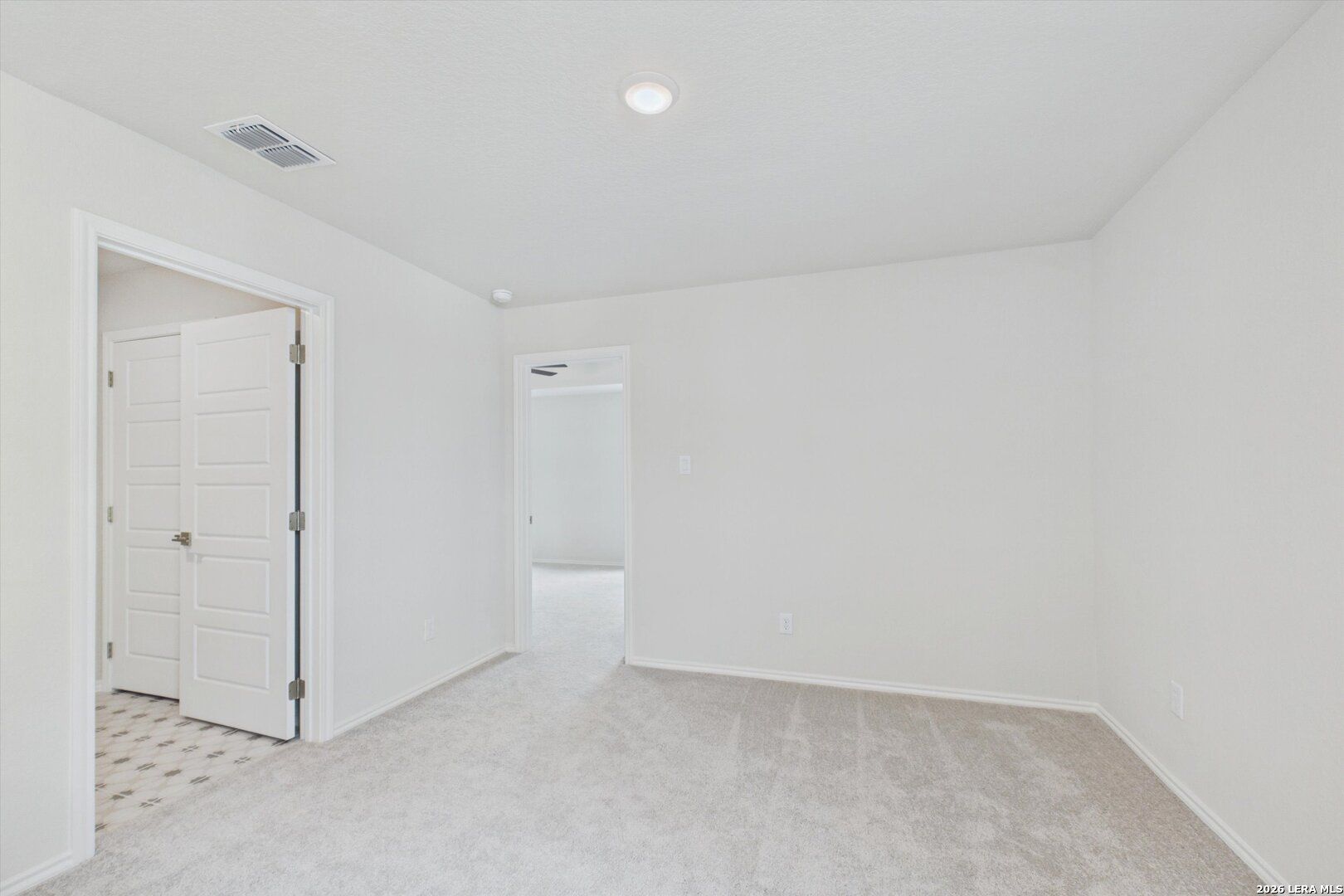 Bright, neutral-toned secondary bedroom with plush carpeting in The Charlotte B floor plan at Meadows at Oak Creek.