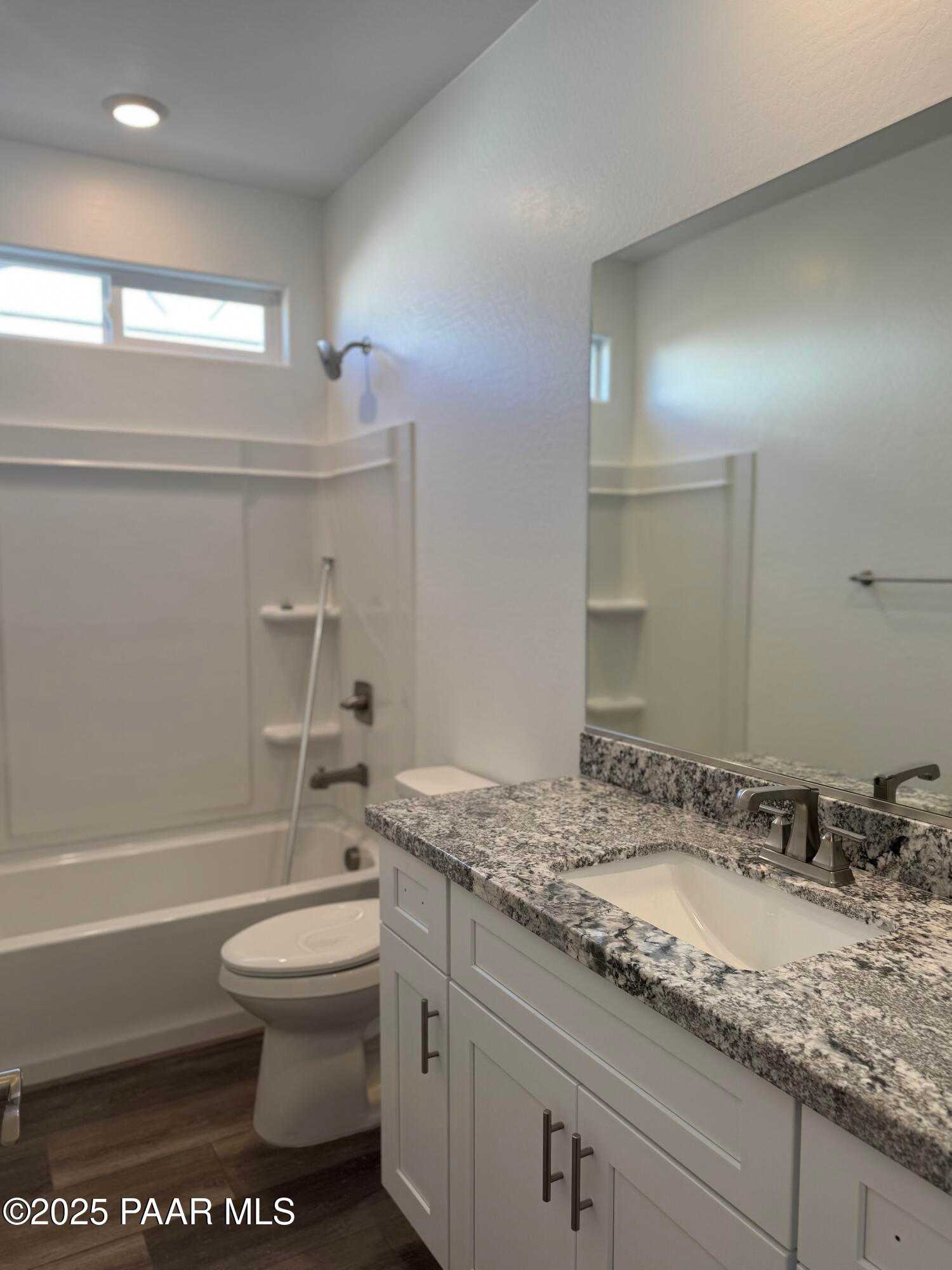 Modern bathroom with granite vanity, soaking tub, glass shower, and toilet in Davidson Homes The Sunrise II A, Prescott, Arizona