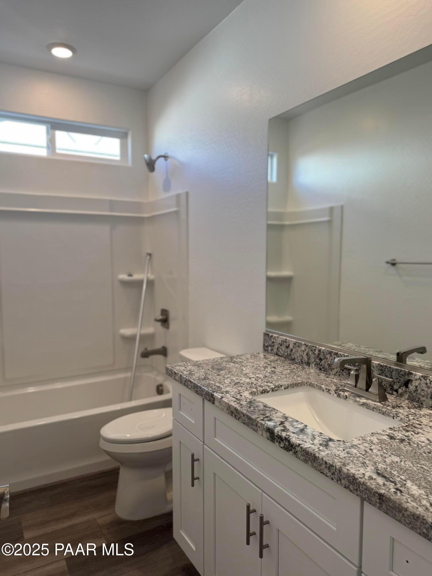 Modern bathroom with granite vanity, soaking tub, glass shower, and toilet in Davidson Homes The Sunrise II A, Prescott, Arizona