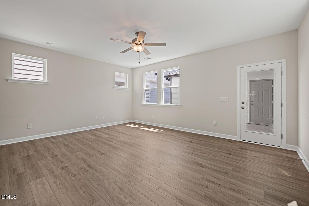 Bright, spacious living area with wood-look flooring in The Alexander C floor plan by Davidson Homes in Knightdale, NC.