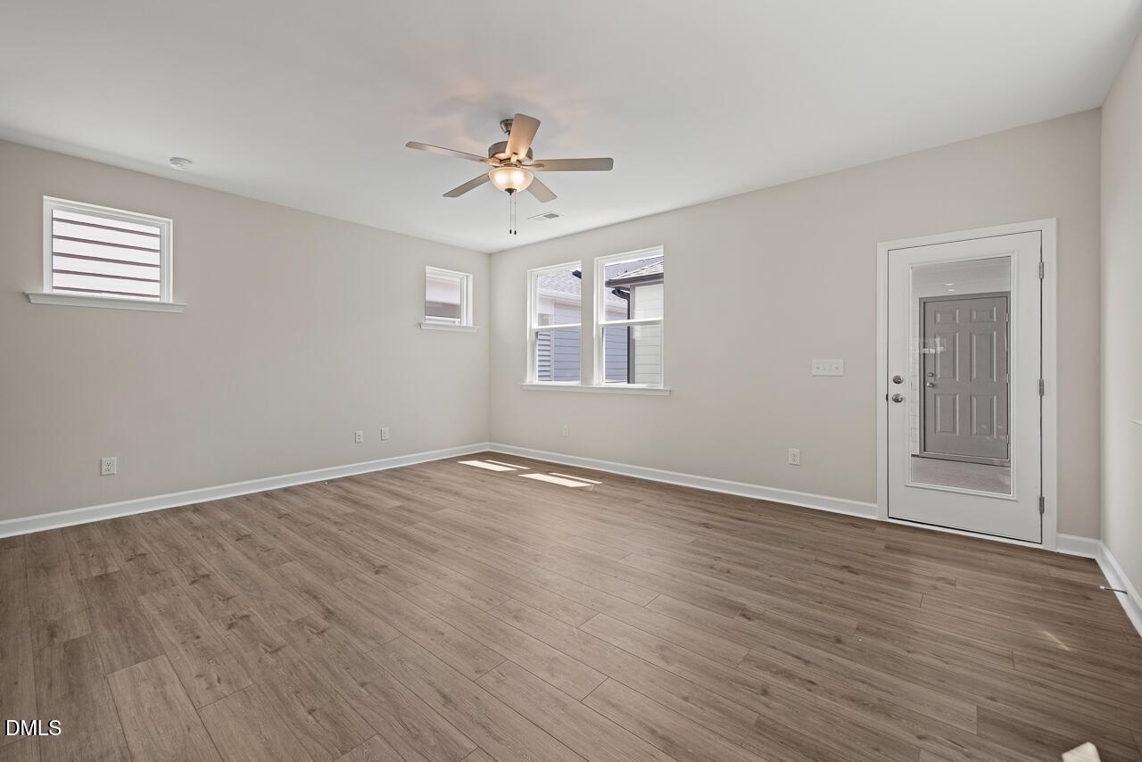 Bright, spacious living area with wood-look flooring in The Alexander C floor plan by Davidson Homes in Knightdale, NC.