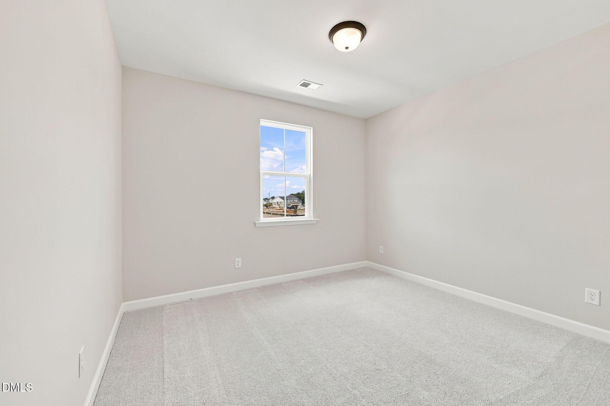 Bright, carpeted bedroom in The Harris C floor plan at Forestville Yard, Knightdale, North Carolina.