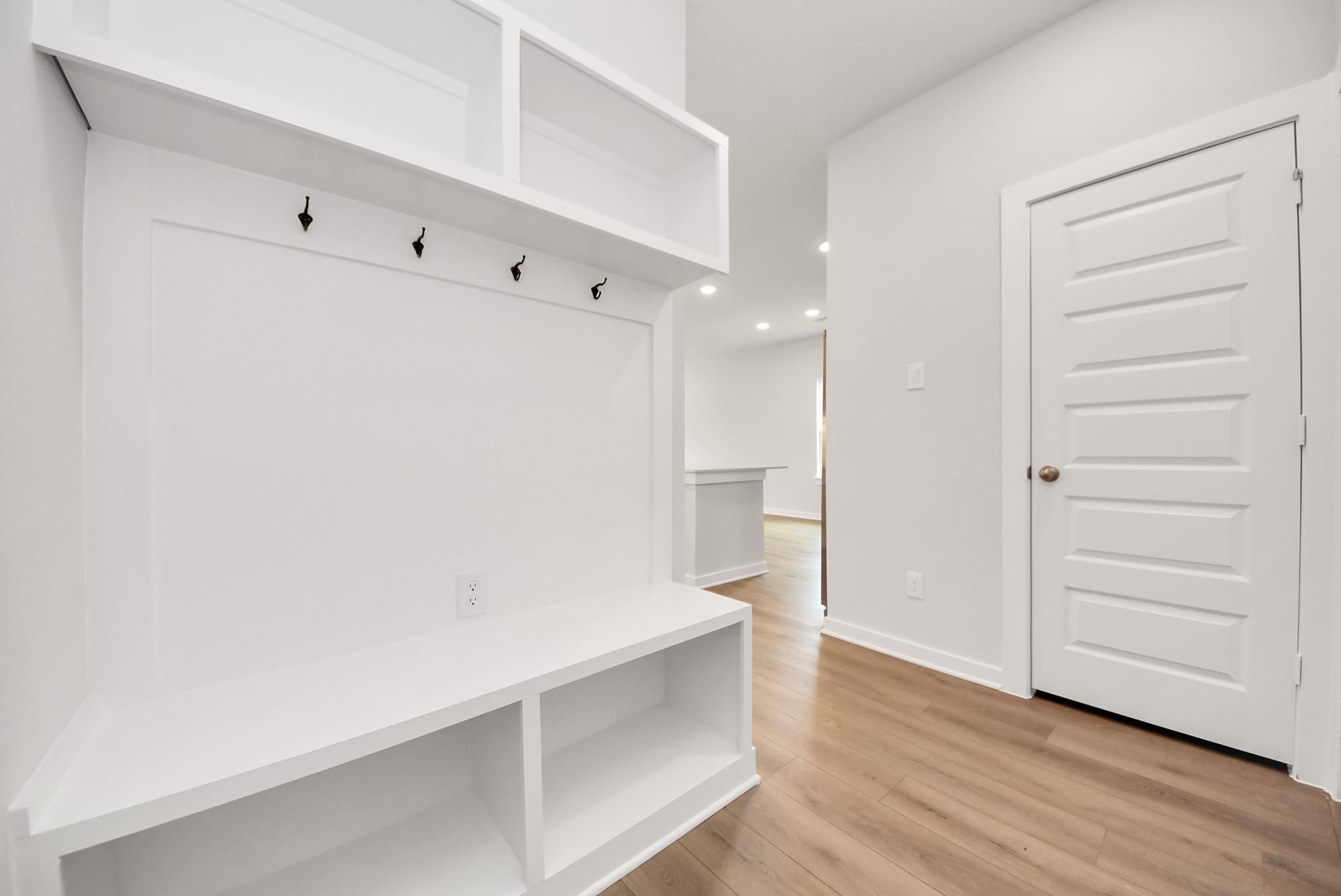 White mudroom bench with coat hooks in a Davidson Homes The Blanco E floor plan at The Villages at WestPointe, Dayton.