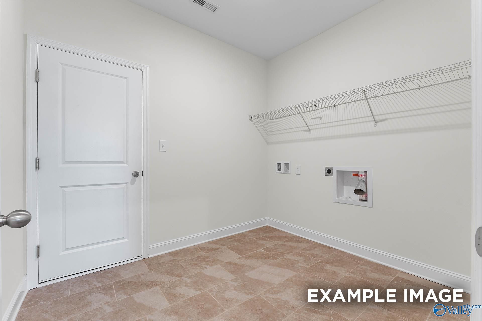 Functional laundry room with wire shelving, washer/dryer hookups, utility sink, and beige tile floor in The Emory 4-bedroom home, Toney, Alabama