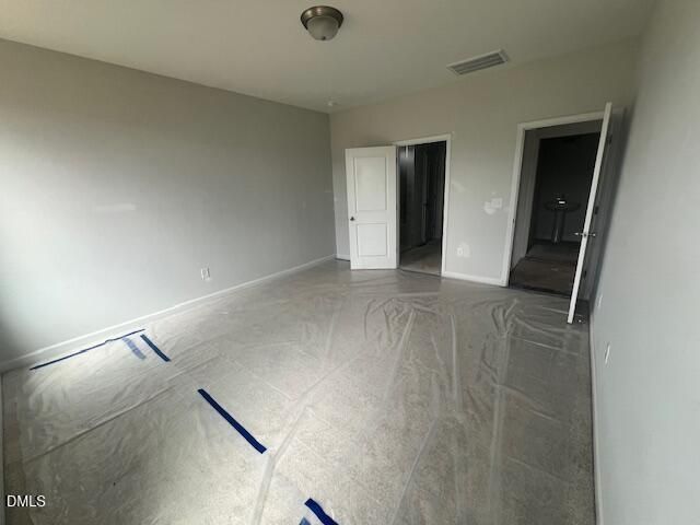 Spacious bedroom with protective floor covering in The Ash B floor plan at Retreat at North Main in Lillington, North Carolina.
