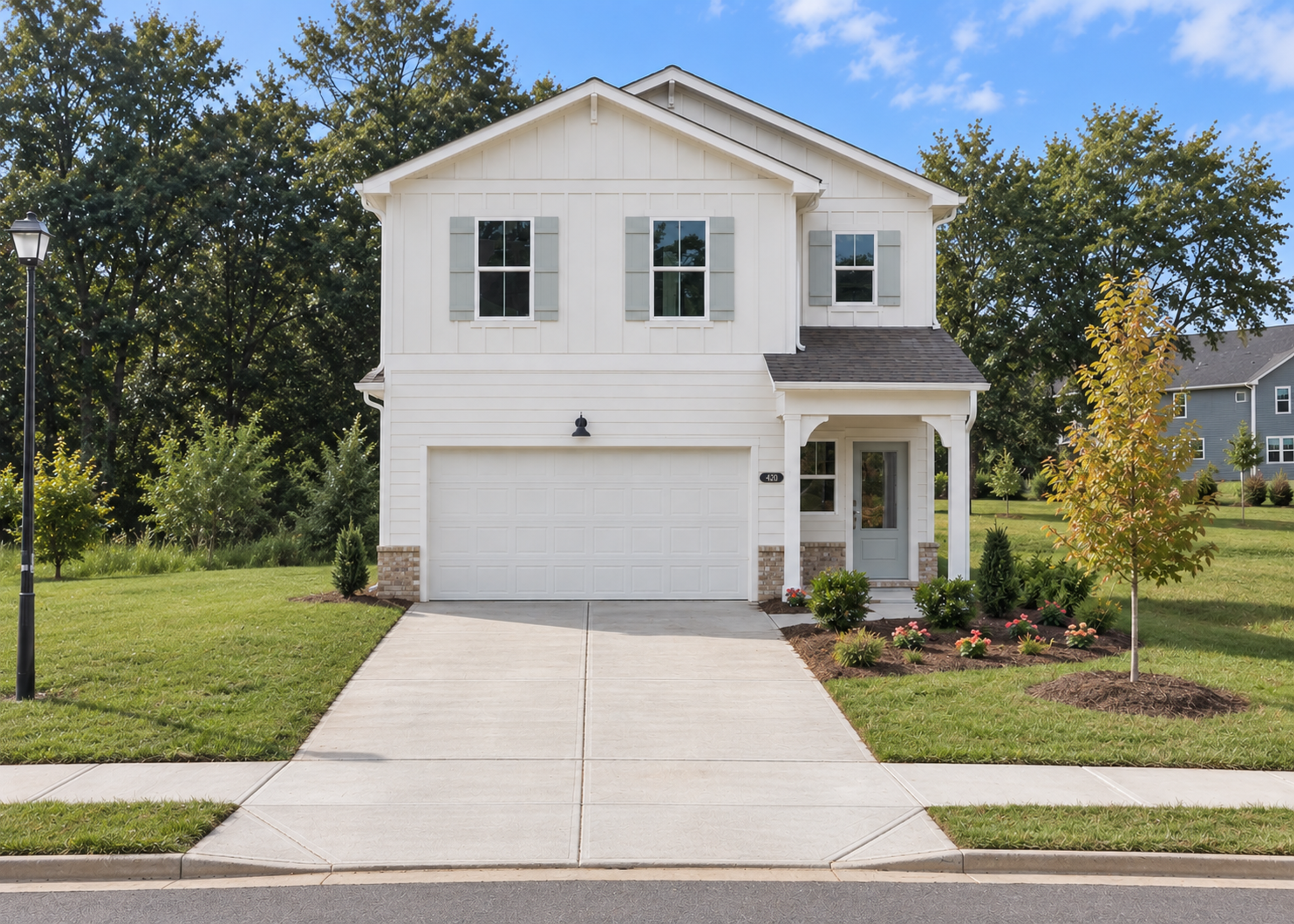 Modern white farmhouse exterior by Davidson Homes at Greene Farm in Cartersville, Georgia with two-car garage.