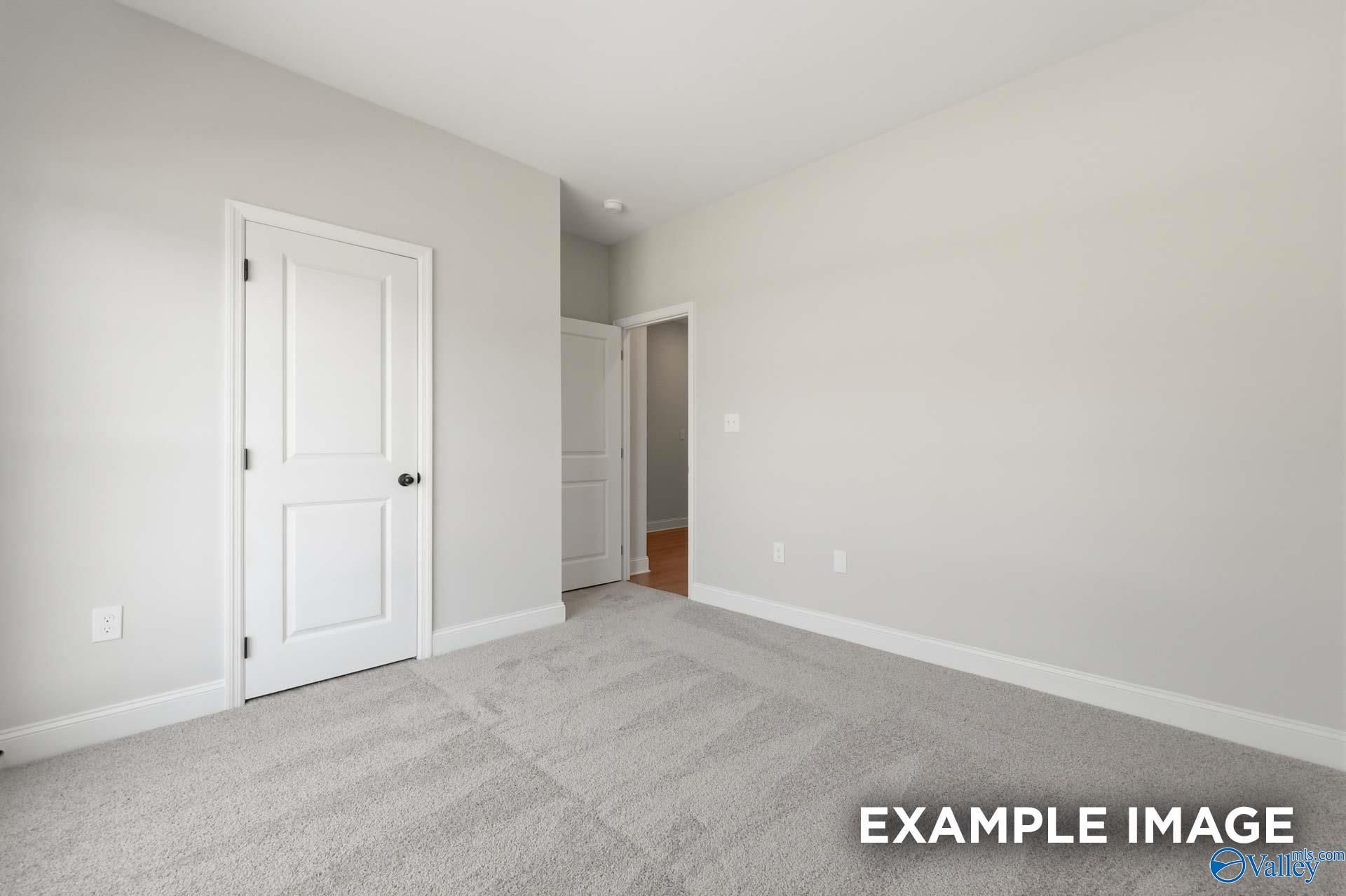 Spacious secondary bedroom with neutral carpet in The Franklin C floor plan at The Highlands in Arab, Alabama.