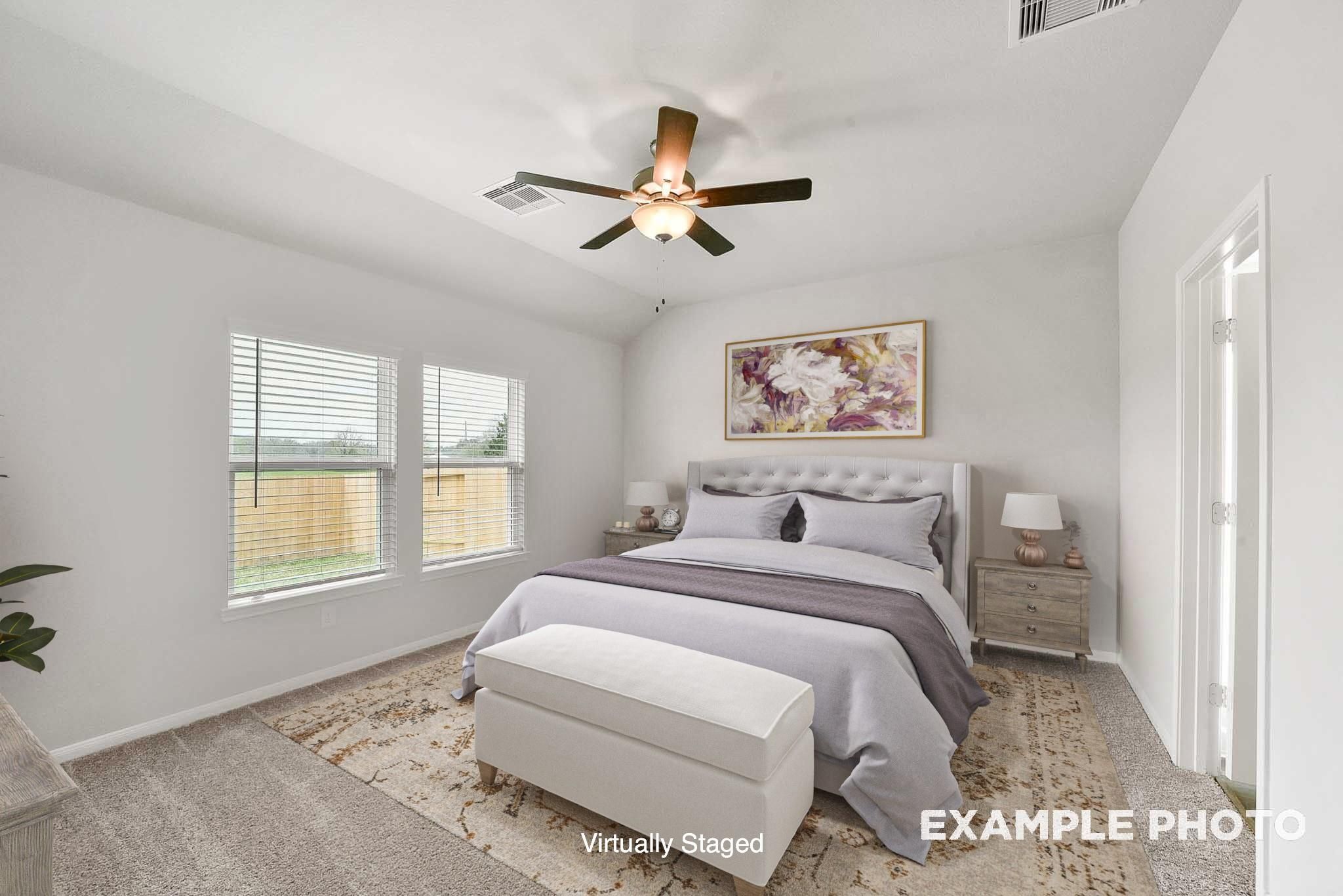 Cozy secondary bedroom with ceiling fan, tufted bed, plush purple bedding, and large windows in Davidson Homes The Tierra B, Beasley, Texas