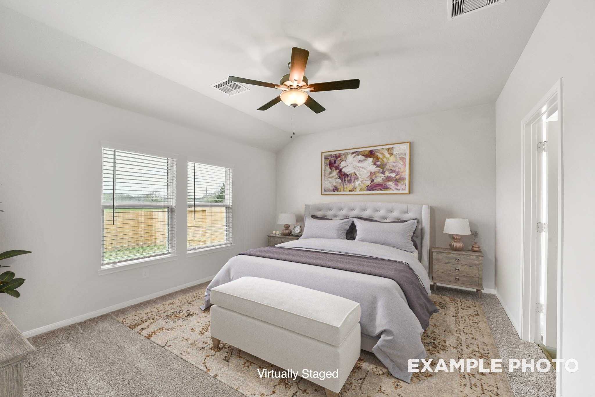 Cozy secondary bedroom with ceiling fan, tufted bed, plush purple bedding, and large windows in Davidson Homes The Tierra B, Beasley, Texas