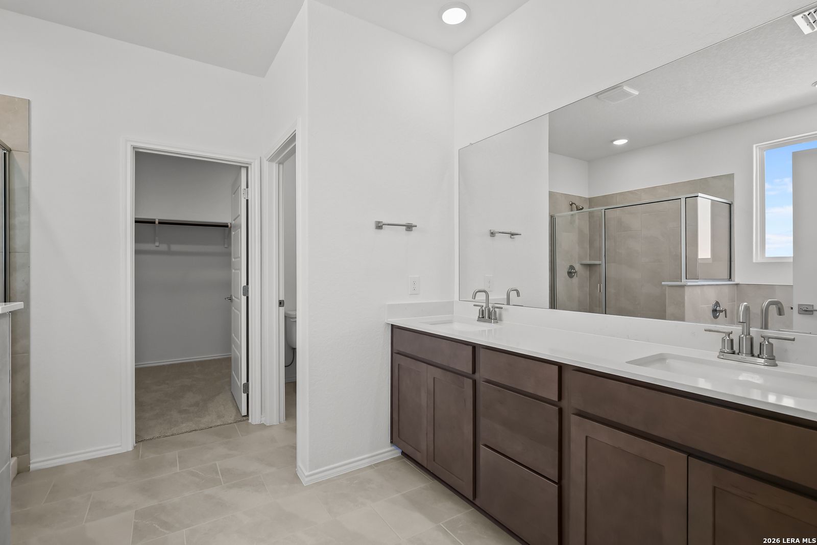 Elegant master bathroom with double vanity, walk-in shower, and closet in Davidson Homes Sequoia B, San Antonio, Texas