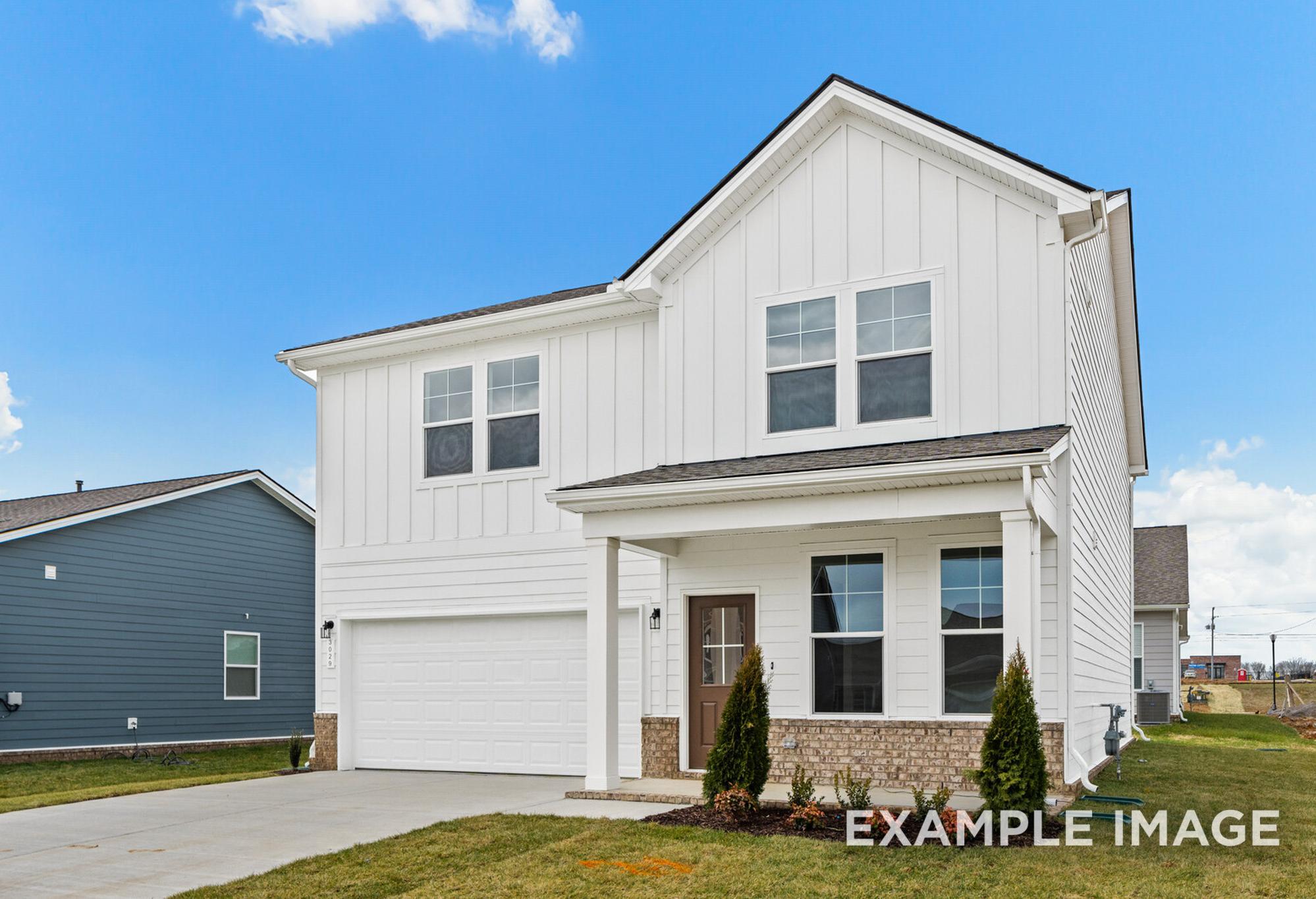 Modern farmhouse exterior of The Logan C two-story home with white board and batten siding, covered porch, and two-car garage in White House, TN
