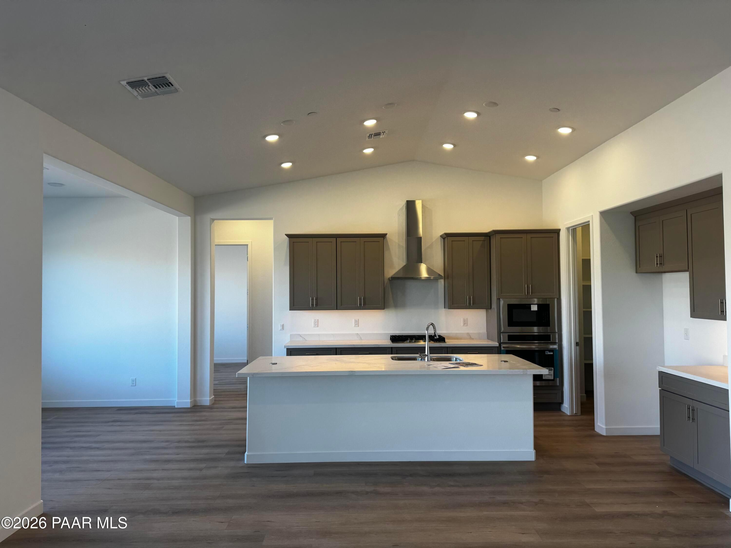 Open-concept kitchen with white island, stainless steel appliances, recessed lighting in Davidson Homes The Blaze C, Prescott, AZ