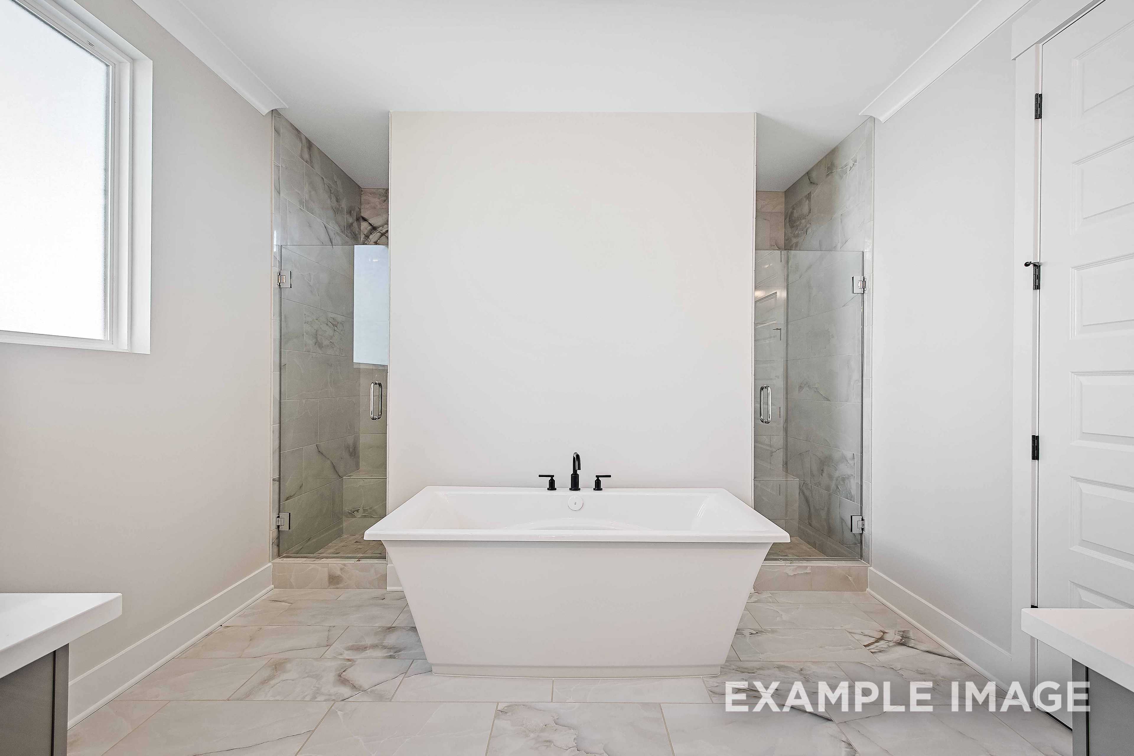 Spacious master bathroom in The Alston A with freestanding soaking tub, glass-enclosed shower, and tiled floors