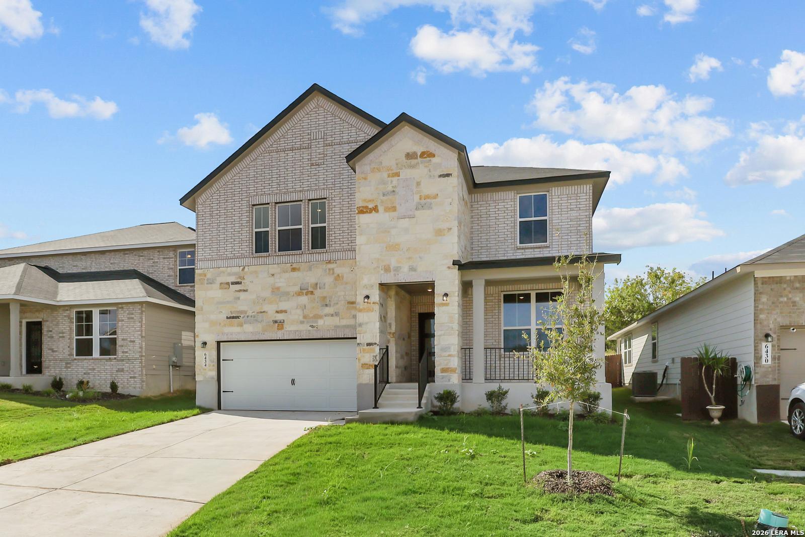 Two-story brick and stone exterior with 2-car garage and covered porch, Davidson Homes The Sequoia C in Royal Crest, San Antonio, Texas