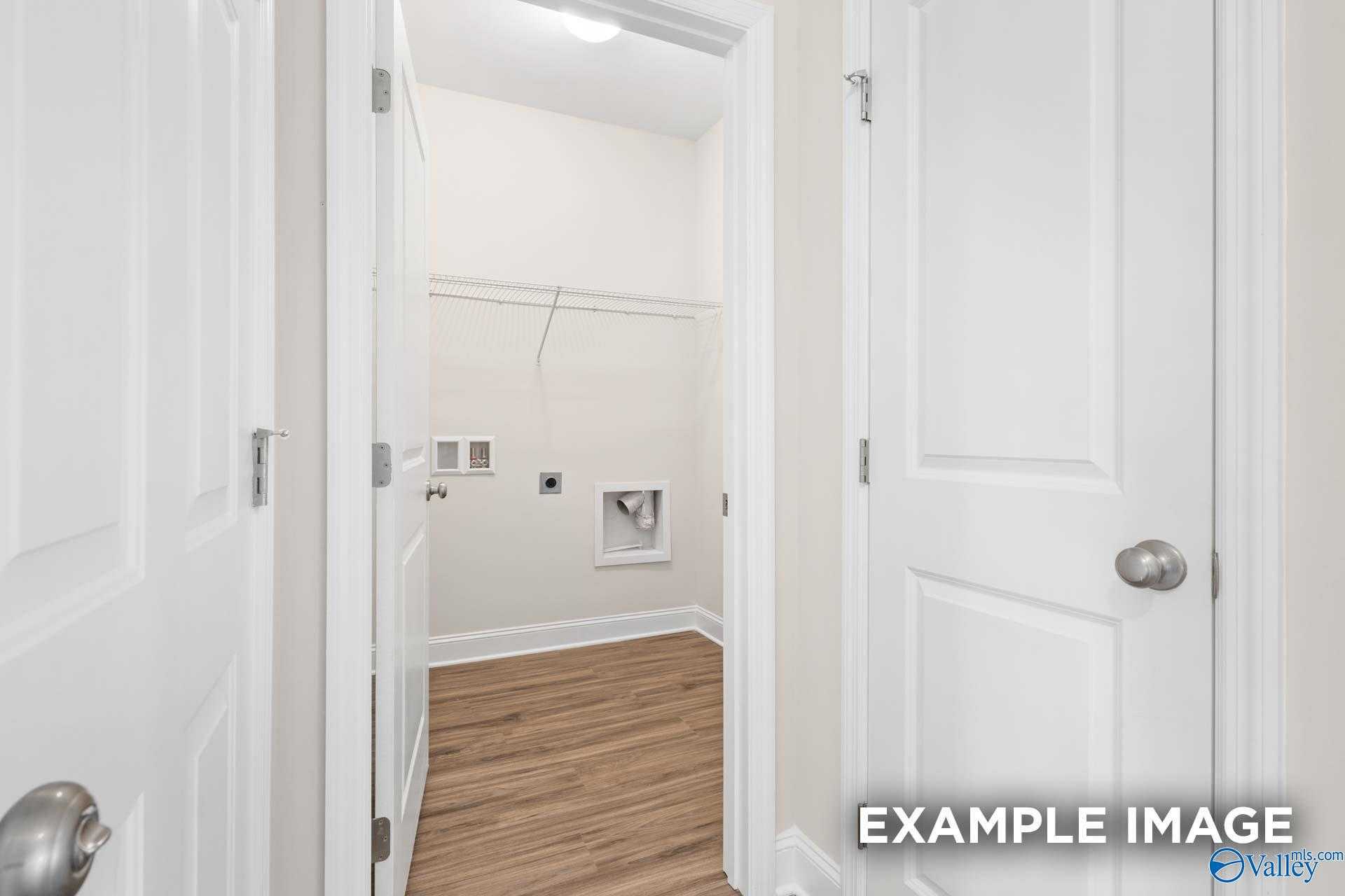 Spacious laundry room with washer dryer hookups, utility sink, and open shelving in Davidson Homes The Franklin, Meridianville, Alabama