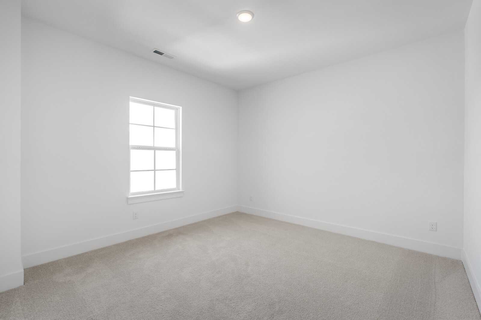 Bright secondary bedroom with large window, white walls, and beige carpet in The Hawkins 4-bedroom home, Murfreesboro, TN