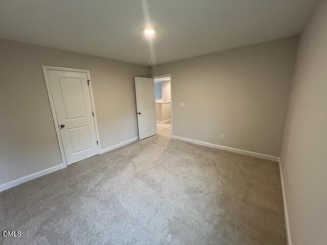 Spacious carpeted bedroom with neutral walls and walk-in closet in Davidson Homes The Willow D floor plan, Lillington, North Carolina