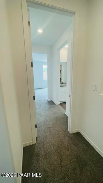 Bright hallway with plush carpeting leading to bedroom and bathroom in The Summit A floor plan, Westwood, Prescott, AZ.