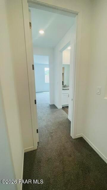 Bright hallway with plush carpeting leading to bedroom and bathroom in The Summit A floor plan, Westwood, Prescott, AZ.