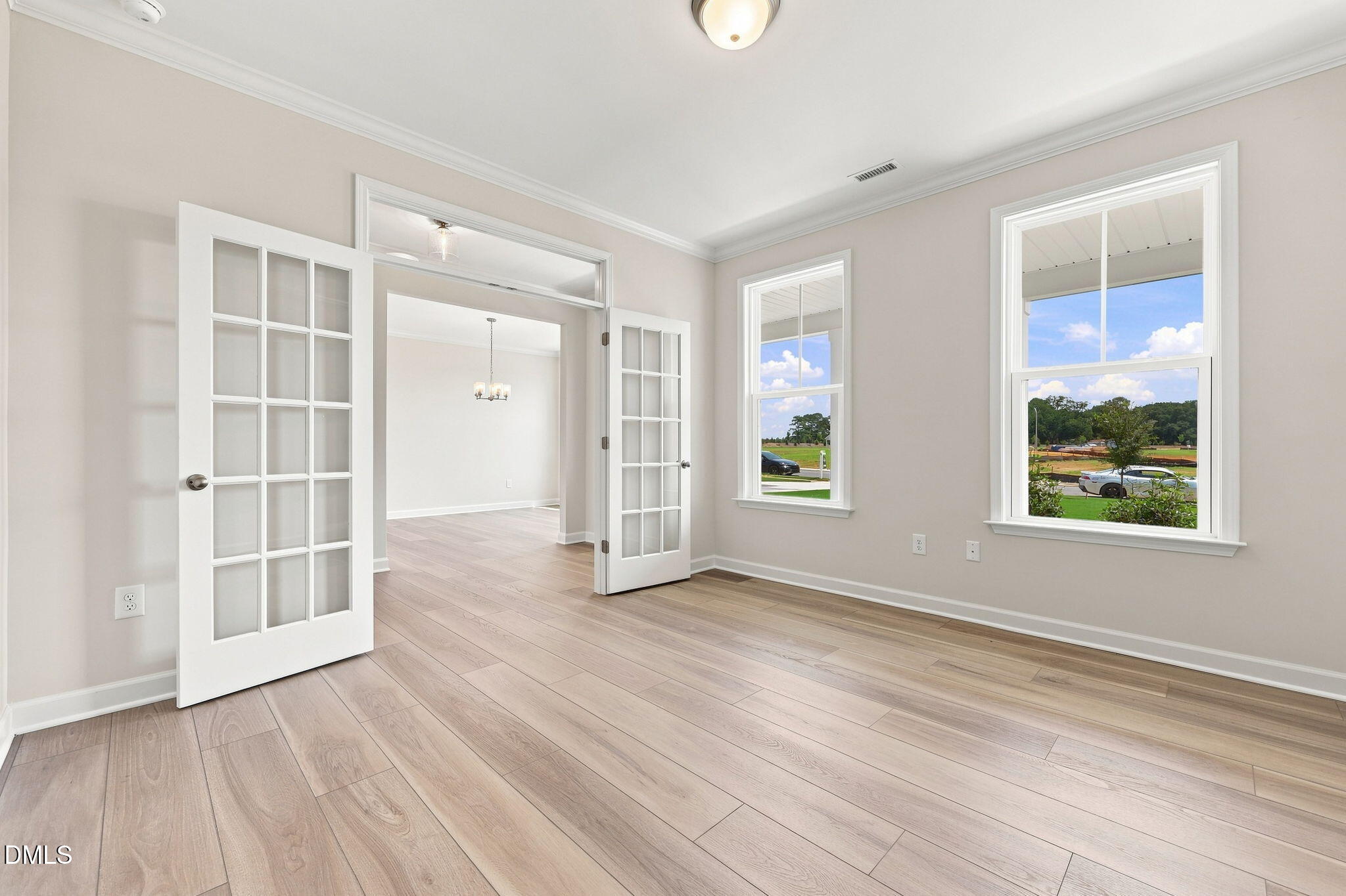 Bright flex room with French doors and wood-look flooring in The Magnolia B floor plan, Retreat at North Main, Lillington.