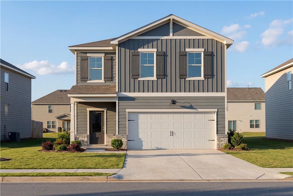 Modern two-story gray home with 2-car garage, front porch, and lush landscaping in The Bluffs, Canton, Georgia by Davidson Homes