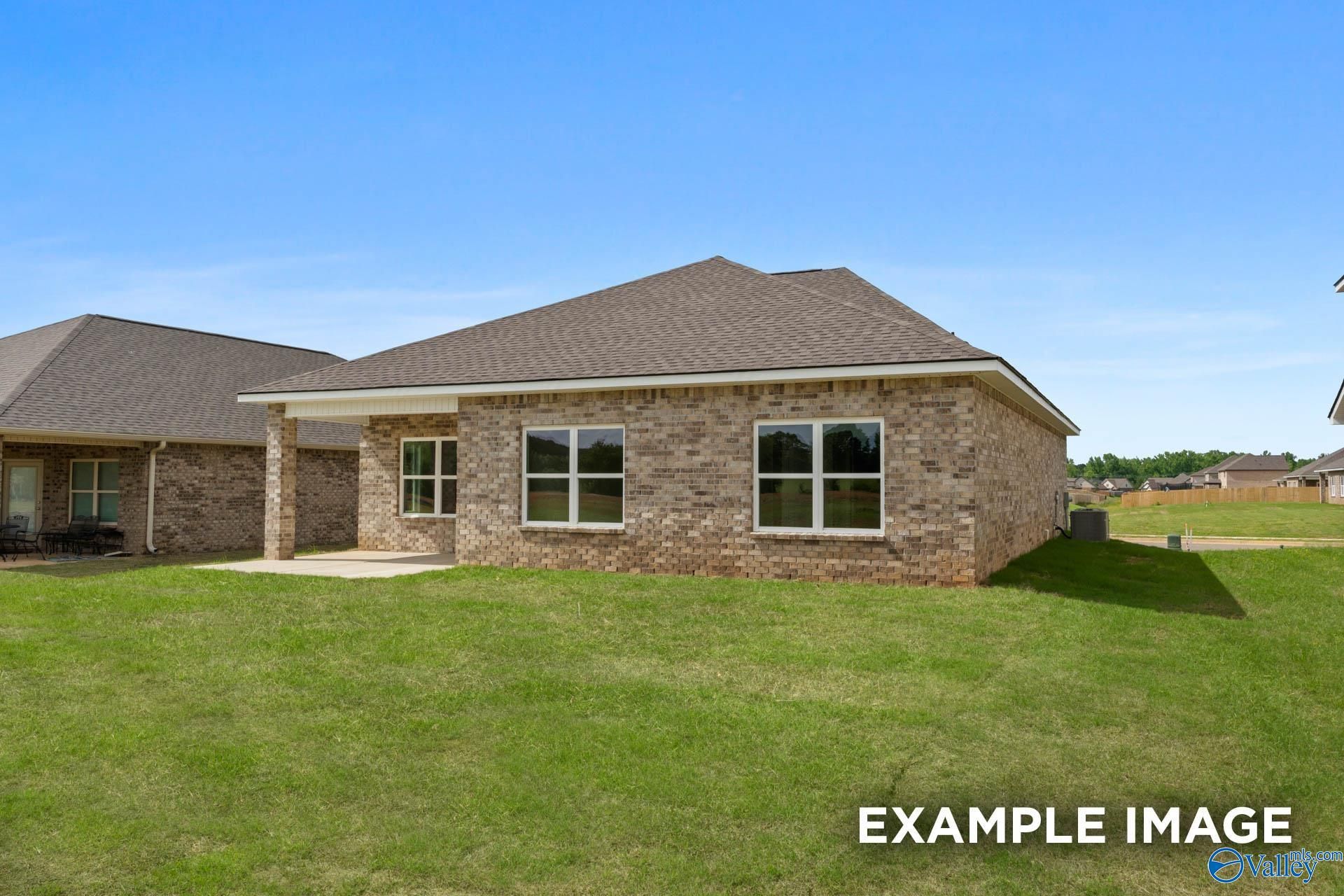 Back exterior view of brick Franklin C floor plan home with covered patio in Heritage Lakes, New Market, Alabama.