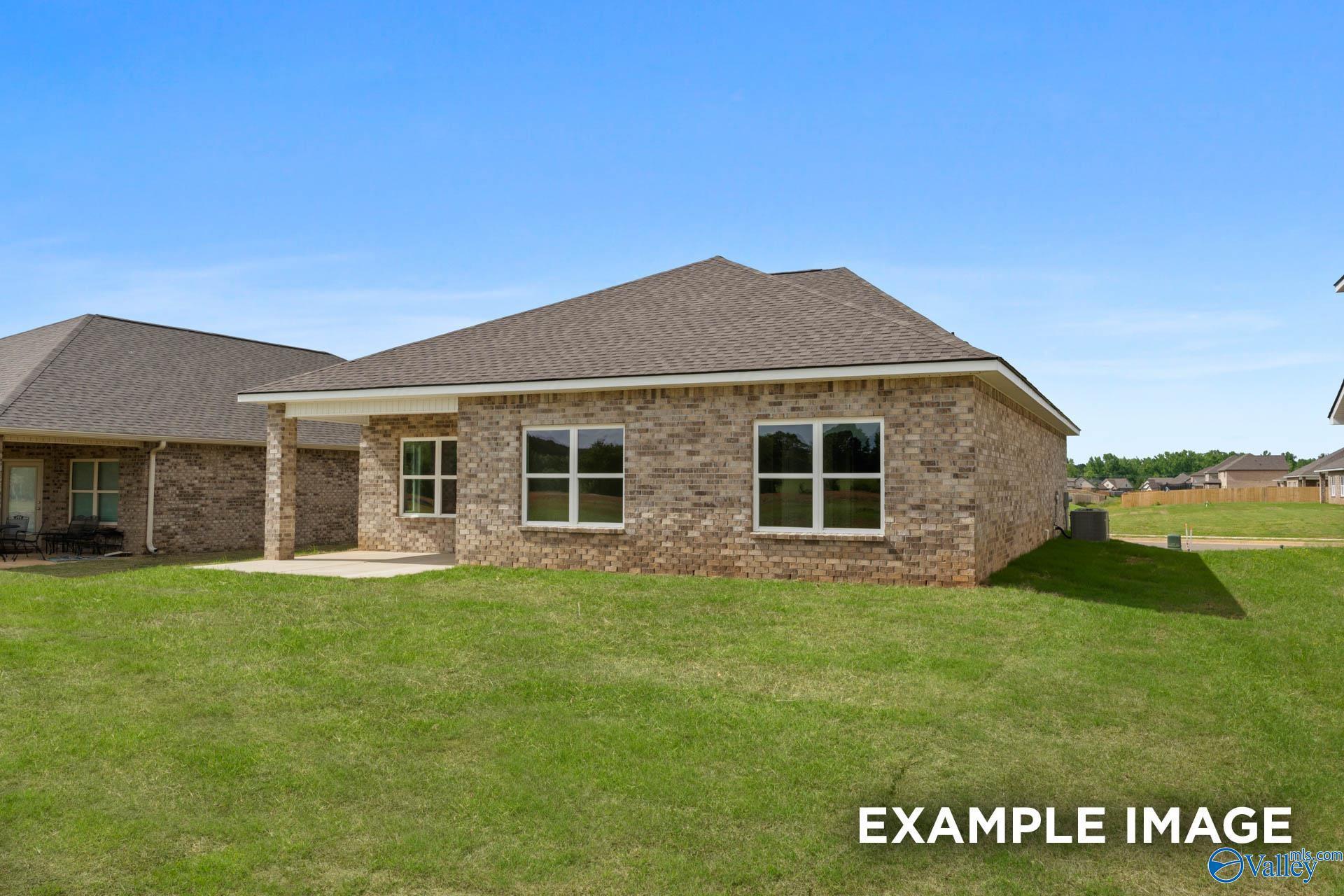 Back exterior view of brick Franklin C floor plan home with covered patio in Heritage Lakes, New Market, Alabama.