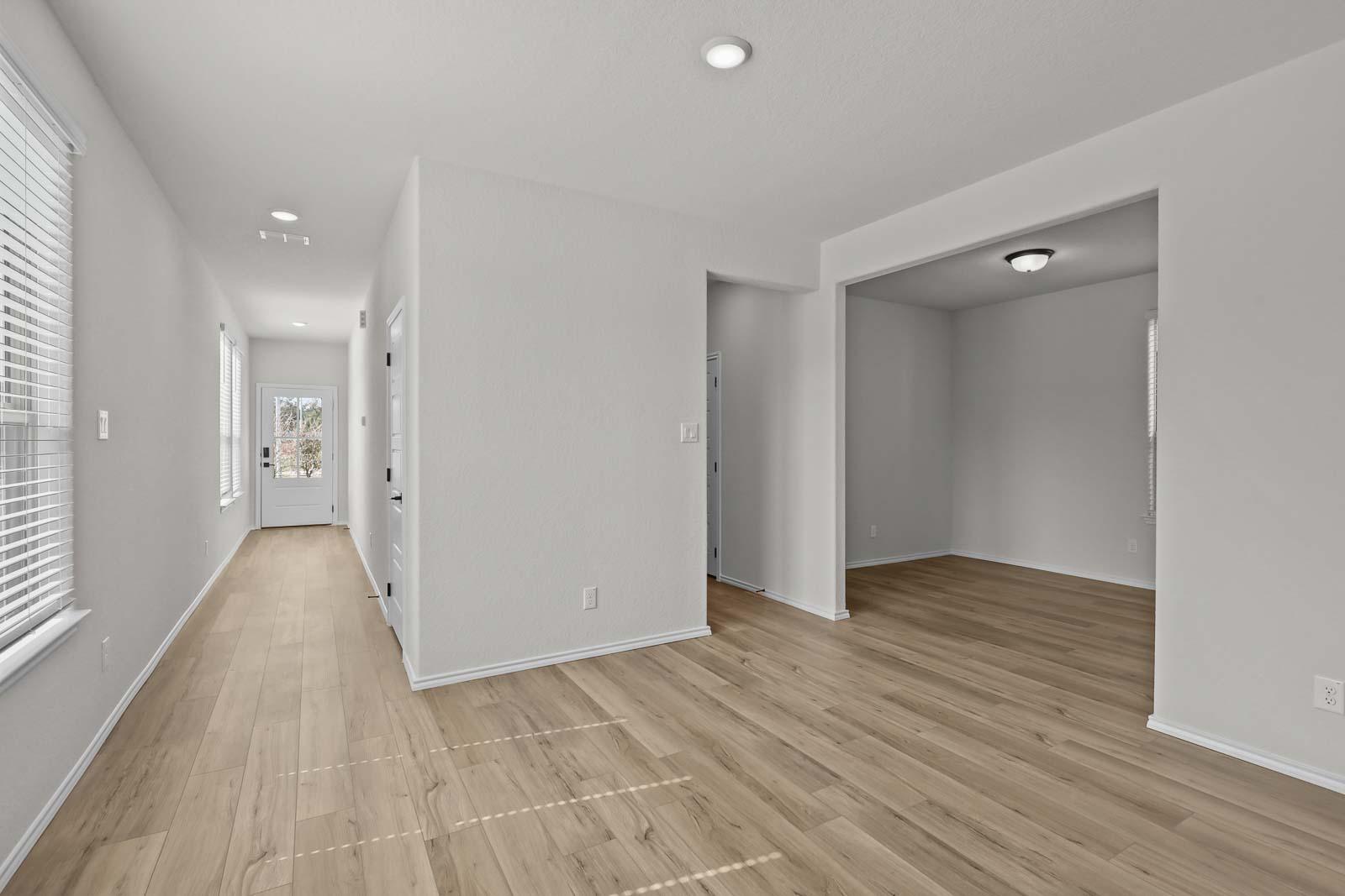 Bright open entryway and hallway of The Florence B featuring modern luxury vinyl plank flooring and neutral wall decor.
