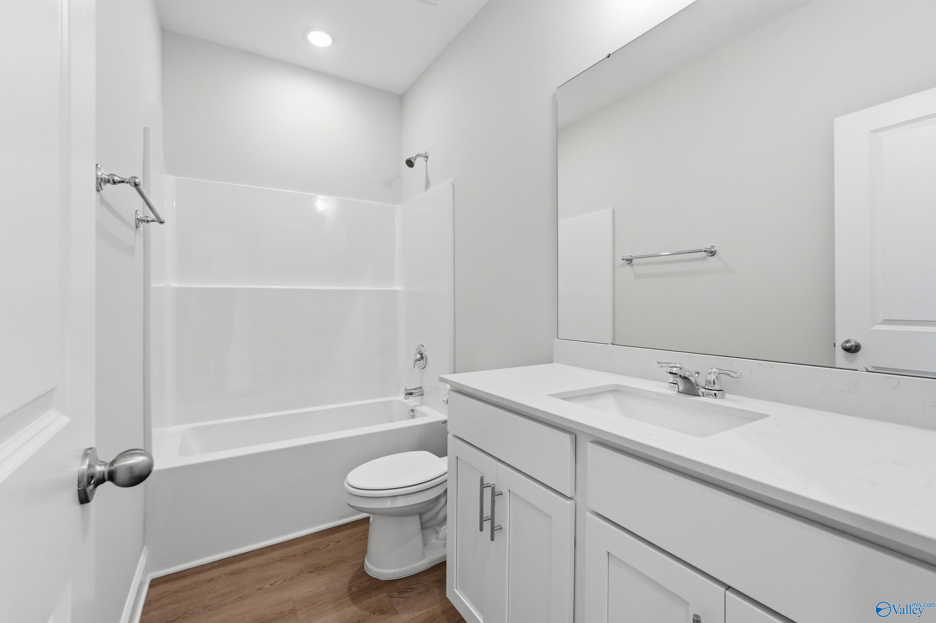 Bright white full bathroom with tub-shower combo, single vanity, and toilet in Davidson Homes The Asheville C, Huntsville