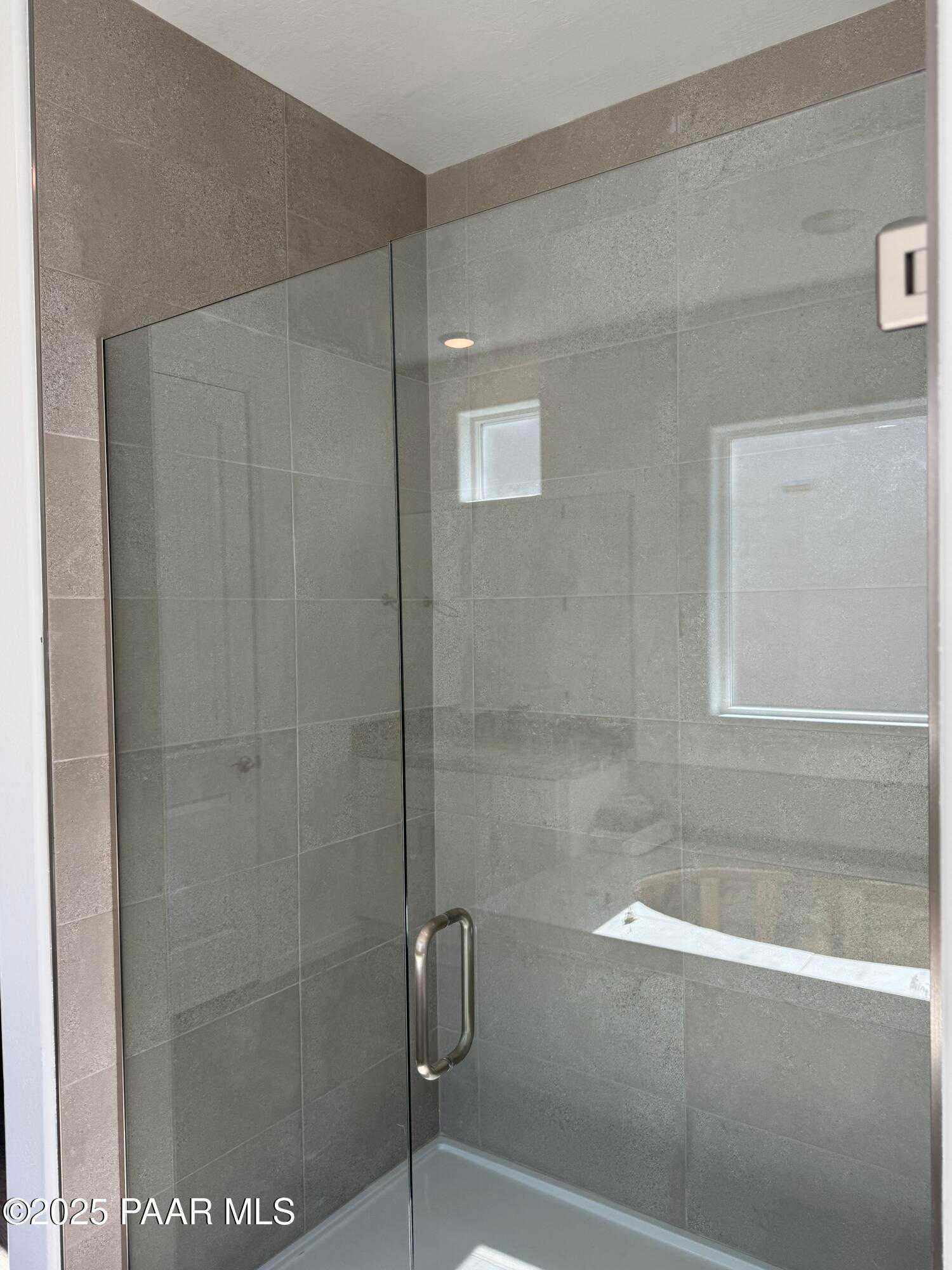 Modern frameless glass shower with neutral tile walls and window in master bath, The Sunrise II A, Davidson Homes, Prescott AZ