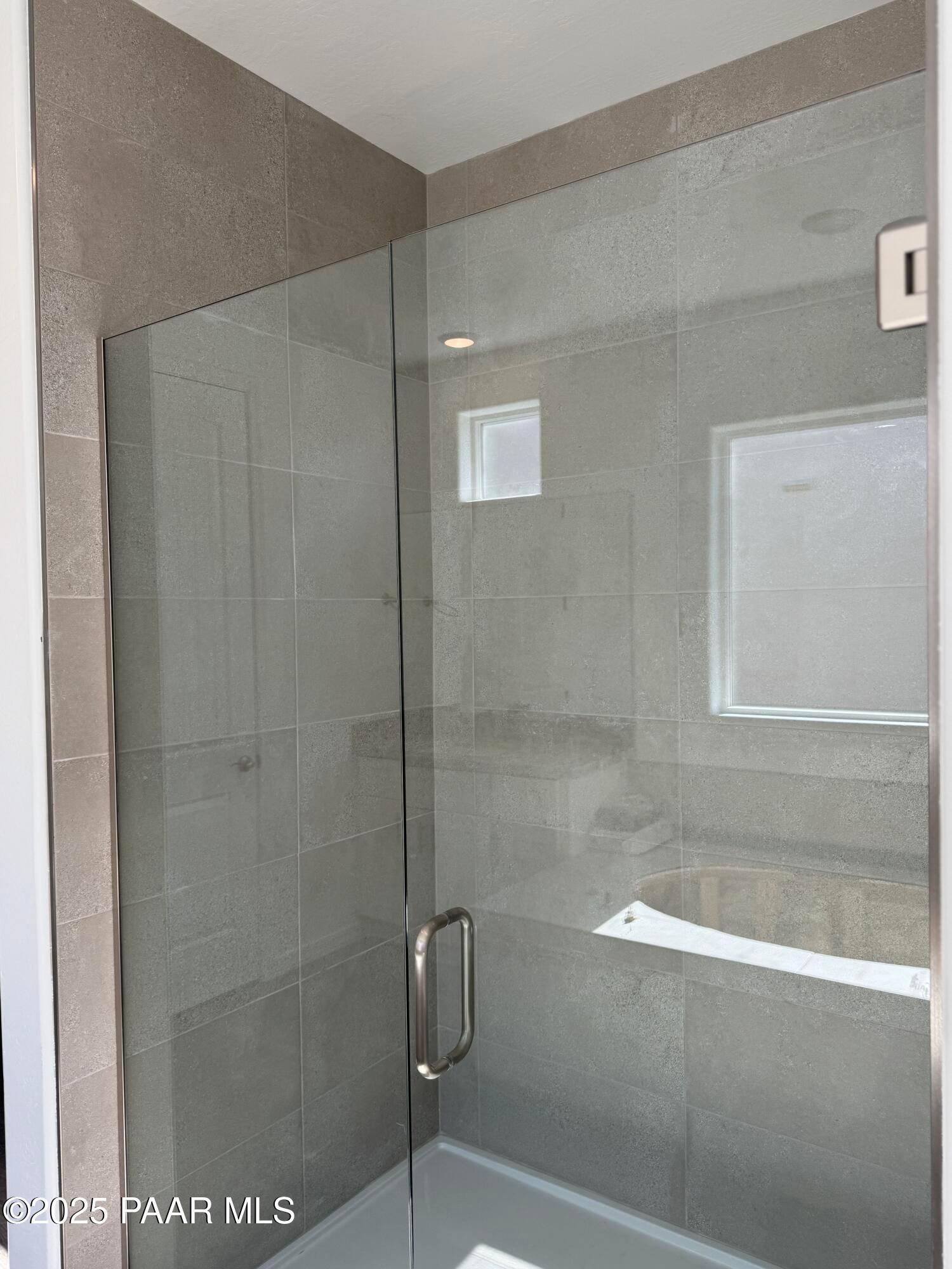 Modern frameless glass shower with neutral tile walls and window in master bath, The Sunrise II A, Davidson Homes, Prescott AZ